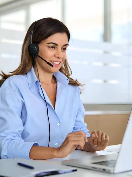 Award-Winning Customer Service A friendly female customer service representative wearing a headset with a microphone smiles as she looks at her laptop screen in a bright, modern office.