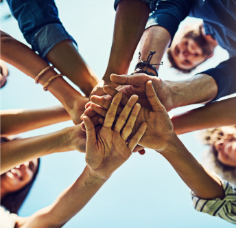 Community Commitment Group of people joining hands together in a circle, symbolizing teamwork and community commitment.