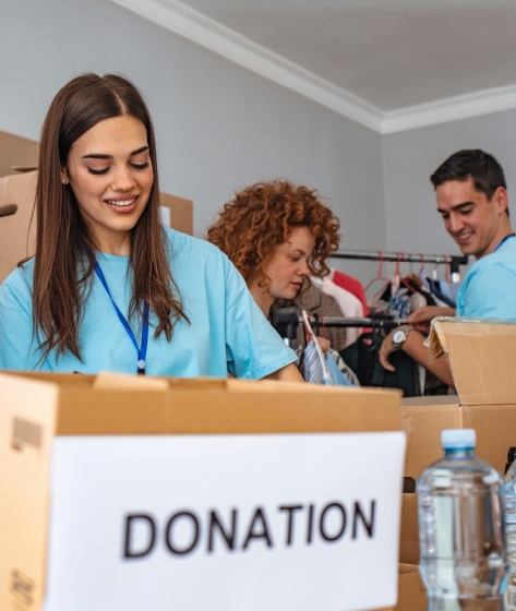 Community Involvement and Recognition Volunteers sorting donated items into boxes labeled 'Donation' at a community center.