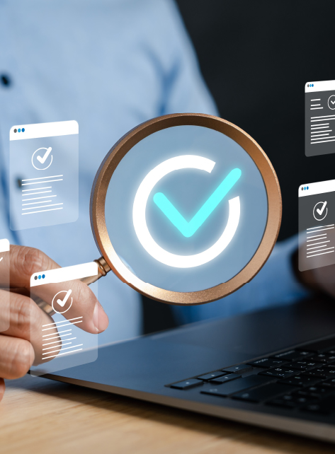 Compliance and Regulatory Guidance Person using a magnifying glass with a digital checkmark icon above a laptop, symbolizing compliance review and regulatory verification.